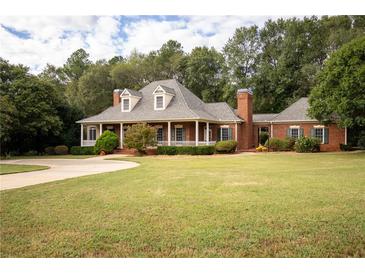 Brick home with a large front porch and landscaped lawn at 75 Rivercreek Xing, Kingston, GA 30145