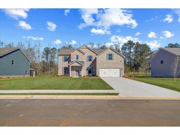 Charming two-story brick home with a well-manicured lawn and a two-car garage at 123 Felicity Pike, Locust Grove, GA 30248