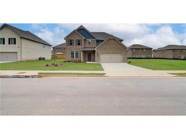 Two-story brick home with a large front yard and driveway at 115 Felicity Pike, Locust Grove, GA 30248