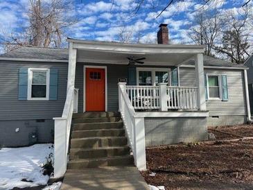 Gray house with a white porch, orange door, and blue shutters at 3006 Dogwood Dr, Hapeville, GA 30354