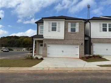 Two-story brick townhome with white accents and a two-car garage at 328 Shine Dr, Stockbridge, GA 30281