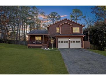 Two-story house with brown siding, two-car garage, and landscaped lawn at 1907 Kelvin Dr, Lawrenceville, GA 30043