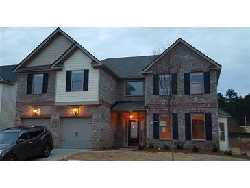 Two-story house with gray and white brick exterior, two-car garage, and landscaping at 416 Culloden Moor Dr, Mcdonough, GA 30253