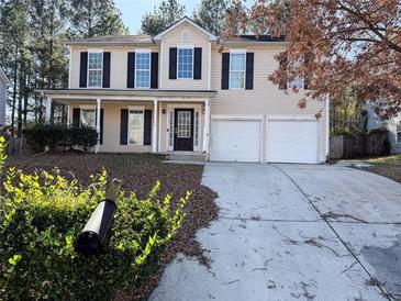 Two-story house with beige siding, black shutters, and a two-car garage at 1760 Marceau Dr, Conley, GA 30288