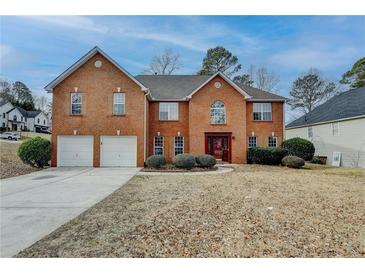 Brick two-story house with attached two-car garage and manicured lawn at 591 Paper Ridge Ct, Lawrenceville, GA 30046