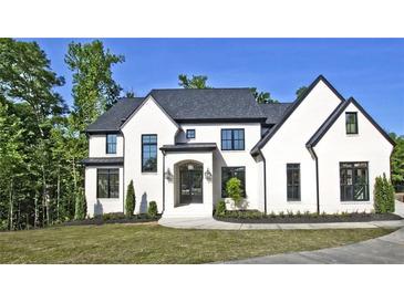 Stunning white brick home with black trim, landscaping, and a paved driveway at 2346 East Maddox Rd, Buford, GA 30518