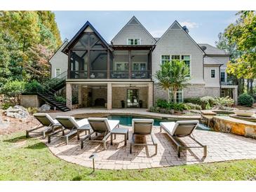 Stunning backyard pool area with a covered patio, outdoor seating, and beautiful landscaping at 923 Little Darby Ln, Suwanee, GA 30024