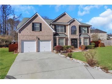 Brick two-story house with a two-car garage and landscaped lawn at 1943 Ivy Branch Ct, Loganville, GA 30052