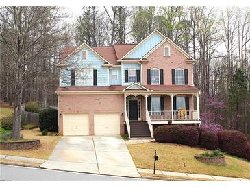 Charming two-story home with brick facade, attached garage, covered porch, and landscaped front yard at 753 Win West Xing, Auburn, GA 30011