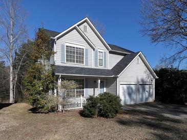 Two-story house featuring gray siding, a two-car garage, and a landscaped yard at 826 Shore Drive, Lithonia, GA 30058