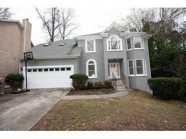 Gray two-story house with white garage door and landscaping at 500 Chimney House Ct, Stone Mountain, GA 30087