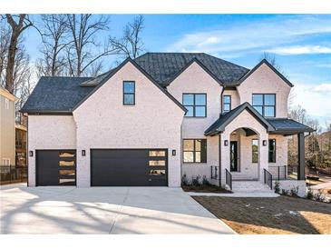 Two-story house with brick facade, black garage doors, and landscaped yard at 2297 Lake Ridge Ter, Lawrenceville, GA 30043