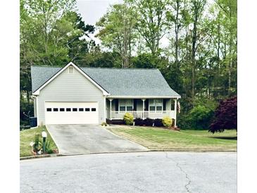 Gray house with a white garage door, front porch, and landscaped lawn at 399 Towler Dr, Loganville, GA 30052