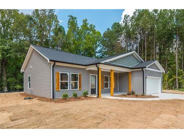 New construction home featuring gray siding, black roof, and a two-car garage with wood accents at 121 Hunters Ln, Powder Springs, GA 30127