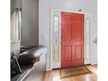 Inviting entryway with red front door and wood floors at 5470 Walnut Ln, Lithonia, GA 30038