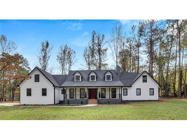 White farmhouse exterior boasts a charming front porch and manicured lawn at 3569 Lynne Rd, Powder Springs, GA 30127