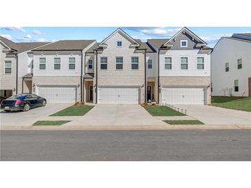 Charming new construction townhomes featuring two-car garages and modern architectural details at 8214 Tiger Way, Riverdale, GA 30296