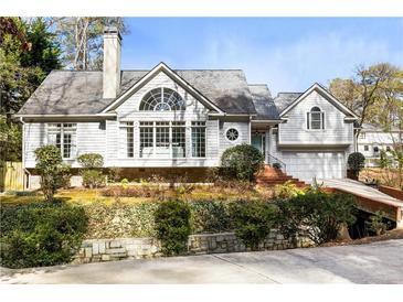 Charming two-story home boasts beautiful landscaping, a brick driveway, and large windows at 1134 Ferncliff Ne Rd, Atlanta, GA 30324