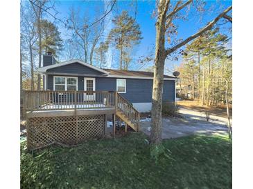 Ranch home with deck, fenced yard, and wooded area at 8791 Daerwater Dr, Winston, GA 30187