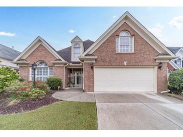 Brick house with a two-car garage and landscaped front yard at 2040 Hickory Station Cir, Snellville, GA 30078