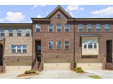 Brick front exterior of charming townhome with two-car garage at 279 Commons Ave, Woodstock, GA 30188