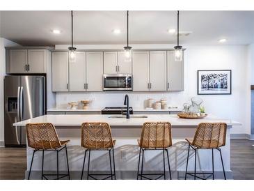 Modern kitchen island with seating and white quartz countertops at 3351 Orwell Way # 2206, Cumming, GA 30041