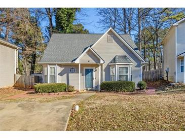Tan house with gray roof, landscaping, and a small driveway at 145 Turning Pt, Stockbridge, GA 30281