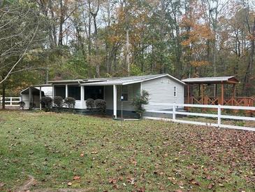 Ranch home with covered porch and detached shed, nestled on a wooded lot at 3780 Hutcheson Ferry Rd, Whitesburg, GA 30185