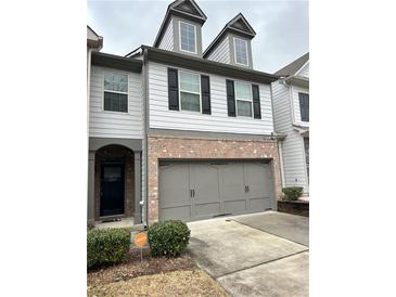 Two-story townhome with gray siding, brick base, and a two-car garage at 2249 Knoxhill Se Vw, Smyrna, GA 30082