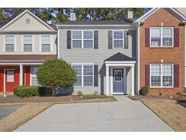 Two-story townhome with gray siding, a blue door, and a small front yard at 1761 Stanwood Nw Dr, Kennesaw, GA 30152