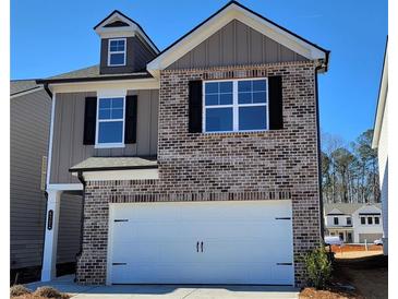 Two-story brick home with a white garage door and landscaping at 4331 Portsbrook Ave, Snellville, GA 30039