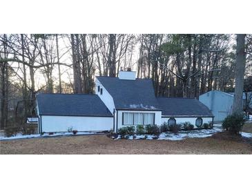 White house with dark gray roof, surrounded by trees, some snow on the ground at 3123 Oak Dr, Marietta, GA 30066