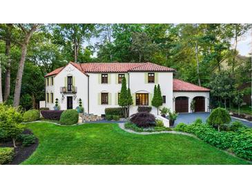 Stunning Spanish-style home with red tile roof, manicured lawn, and mature trees at 1598 W Sussex Ne Rd, Atlanta, GA 30306