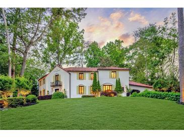 Stunning white two-story house with red tile roof, landscaping, and a large green lawn at 1598 W Sussex Ne Rd, Atlanta, GA 30306