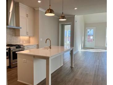 Modern kitchen with quartz island, stainless steel appliances and gold pendant lighting at 519 Godfrey Dr, Cumming, GA 30040