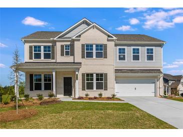 Charming two-story home with a manicured lawn, a brick facade, and a two-car garage at 6210 Misty Hill Ln, Buford, GA 30518