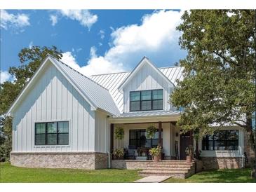 Two-story farmhouse with metal roof, white siding, and brick accents at 1440 Fairview Rd, Ellenwood, GA 30294
