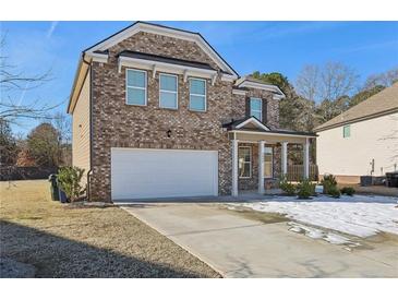 Inviting two-story brick home showcasing a two-car garage and a neatly maintained front yard at 1920 Pearson St, Loganville, GA 30052