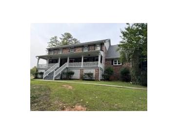 Brick house with large porch and landscaped lawn at 1294 Dogwood Rd, Snellville, GA 30078
