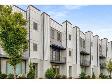 Modern townhouse showcasing clean architectural lines, balconies, and a landscaped yard at 3076 Kelly St, Scottdale, GA 30079