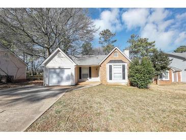 Ranch style home with a white garage door and landscaped lawn at 5277 Brentwood Rd, Atlanta, GA 30349