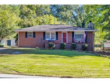 Brick ranch house with a well-manicured lawn and American flag at 156 Main St, Lilburn, GA 30047