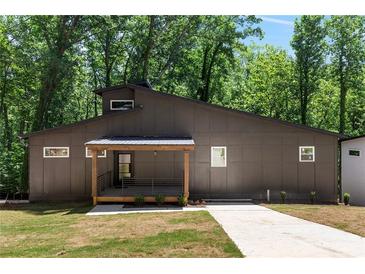 Modern house exterior with dark siding, wood accents, and a landscaped yard at 977 Fleetwood Cir, Atlanta, GA 30311