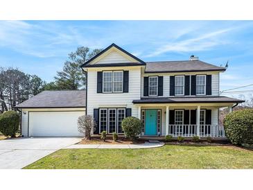 Charming two-story home with a well-manicured lawn and a welcoming blue front door at 125 Cinnamon Fern Cir, Covington, GA 30016