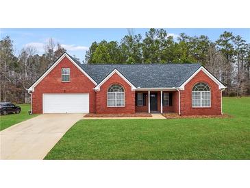 Brick ranch house with gray roof, large windows, and a two-car garage at 435 Berkshire Dr, Covington, GA 30016