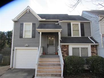 Gray two-story house with a white garage door and wooden steps at 390 Lakeridge Ct, Riverdale, GA 30274