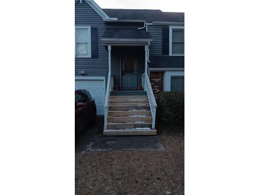 Gray siding house with wooden stairs and a security door at 390 Lakeridge Ct, Riverdale, GA 30274