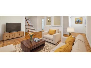 Bright living room featuring wood floors, large windows, modern furnishings, and a staircase at 1634 Ponce De Leon Ne Ave # 514, Atlanta, GA 30307