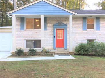 Brick ranch house with blue accents, red door, and landscaped yard at 3464 Creatwood Se Trl, Smyrna, GA 30080