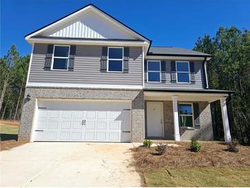 Two-story house with gray siding, white garage door, and landscaping at 80 Heyman Dr, Covington, GA 30016